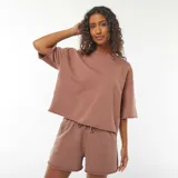 Camiseta color marrón con corte holgado, mangas cortas y cuello redondo.