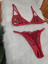 Conjunto de lencería rojo compuesto por un corpiño triangular de encaje con tirantes finos ajustables y una bombacha tipo colaless de encaje con bordes festoneados.