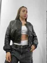 Chaqueta de estilo bomber en color negro con acabado Acid Wash y cierre frontal.