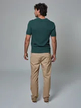 Pantalón color beige de corte regular fit, confeccionado en lino. Cuenta con dos bolsillos frontales y dos bolsillos posteriores, bajo con botamanga y presilla, aplique de badana.