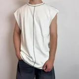 Musculosa blanca de corte holgado con costuras a la vista en cuello, sisas y centro.