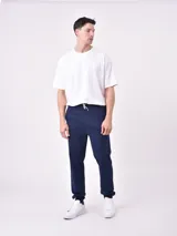 Pantalón de jogging negro con cintura elástica y cordón ajustable. Corte holgado con puños elásticos en los tobillos.
