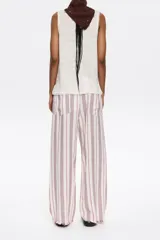 Pantalón de corte jogger con largo tobillero y cintura ajustable con cordón. Diseño a rayas verticales rojas y blancas.