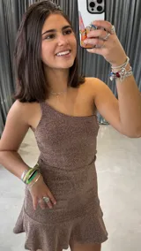 Vestido corto dorado con brillos, de un solo hombro y falda con volados.
