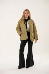 Campera verde militar capitoné de corte amplio, con manga larga y cierre frontal con broches metálicos a presión.