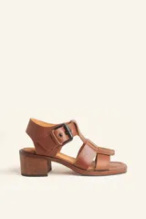 Sandalia de cuero color marrón con tiras anchas, hebilla lateral y taco ancho de madera.