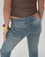 Pantalón de jean Diesel de tiro bajo y corte acampanado, color celeste con desgaste en los muslos.