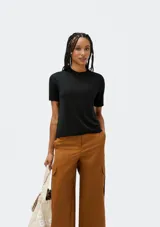 Blusa color beige de tejido de punto, con cuello redondo y mangas cortas.