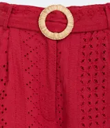 Pantalón pantacourt color ladrillo con textura de laise, bolsillos laterales, cinturón con hebilla forrada y cierre frontal con cremallera.