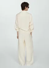 Pantalón de vestir color crema, de corte wide leg, con cintura elástica y bolsillos laterales.