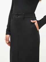Falda midi negra de corte recto, con cintura alta, bolsillos laterales y cierre frontal con botón.