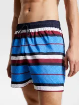 Short de baño Tommy Hilfiger con estampado de rayas horizontales en azul, blanco y rojo. Diseño con monograma TH estampado en azul sobre las rayas azules. Cintura elástica con cordón ajustable.