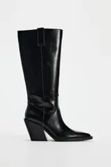 Bota alta negra de cuero sintético, estilo cowboy, con punta fina y tacón geométrico.