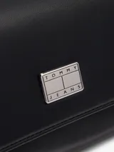 Cartera Tommy Jeans negra con asa superior, correa ajustable y cierre de solapa magnético.