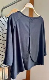 Blusa color beige de viscosa elastizada, con cuello bote y espalda cruzada. Estampado frontal con ilustración de una cara con corona de flores.