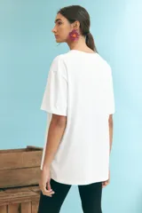Remera blanca de algodón con estampado de un sol en el centro.