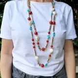 Collar largo de cadena de bronce con cuentas de coral, turquesa y nácar.