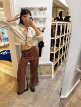 Pantalón sastrero color beige de lino, corte recto y tiro alto, con bordado de caballo en el bolsillo trasero.