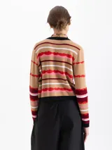 Cardigan corto de punto con estampado de rayas onduladas en tonos beige, rojo, rosa y blanco. Tiene cuello en V, botones frontales y ribetes negros en el escote y puños.