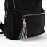 Mochila negra de tela impermeable con cierre de cremallera plateada, bolsillo frontal con cierre y llavero de cuerdas de colores.
