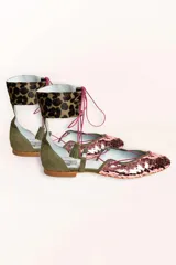 Bailarinas chatitas con punta cubierta de lentejuelas rosadas, laterales y talón de gamuza verde oliva, y tobillera de cuero con estampado animal print. Se atan al tobillo con cordones rosas y tienen un pequeño fleco decorativo en el talón.