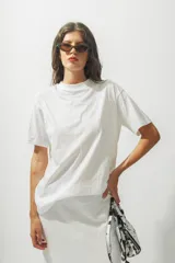 Remera blanca de algodón con cuello redondo y estampado pequeño con el logo de la marca en el pecho.