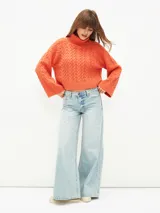 Sweater tejido color naranja oscuro, con cuello alto y mangas largas acampanadas.
