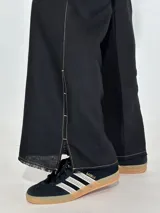 Pantalón de jean blanco de corte ancho con aberturas laterales en el ruedo y costuras a contratono.
