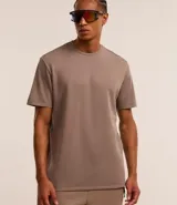 Remera deportiva marrón de corte clásico, confeccionada en tejido tech fleece con tecnología dry, cuello redondo y mangas cortas.