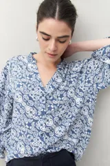Camisa de manga larga estampada en azul y blanco, confeccionada en viscosa, con cuello mao con pequeño volado y mangas con leve volumen.