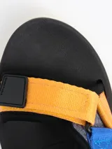 Sandalias con plataforma blanca y tiras de velcro ajustables en colores rojo, azul y amarillo.