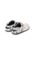 Zuecos con estampado animal print en blanco y marrón, con tira trasera ajustable con hebilla metálica.