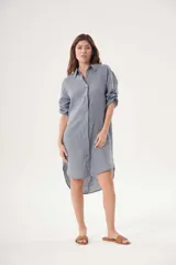 Vestido camisero blanco de lino, con cuello clásico, cierre frontal con botones y mangas 3/4 con trabillas.