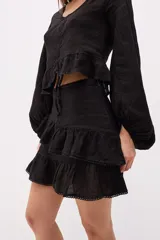 Minifalda marrón con volados superpuestos y terminaciones deshilachadas.