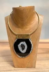 Collar plateado con colgante de piedra agata en tonos negros y grises, con diseño contemporáneo.