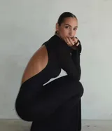 Vestido largo negro de manga larga y cuello alto, con espalda completamente descubierta.