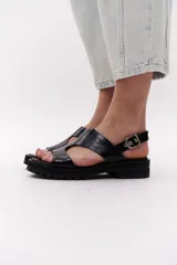 Sandalias marrones de cuero con suela track negra y hebilla plateada.