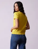 Buzo amarillo tejido en hilado fino, con cuello redondo y mangas cortas.