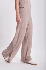 Pantalón largo de lanilla color taupe, de corte ancho y textura acanalada, con aberturas laterales en el ruedo.