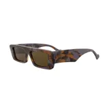 Lentes de sol Gucci con montura rectangular gruesa con estampado de camuflaje en tonos marrones, grises y lilas. El logo de la marca está grabado en dorado en la patilla.