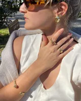 Anillo dorado con diseño de tres bandas entrelazadas.