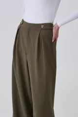 Pantalón negro de poliéster, de corte recto y tiro alto, con pinzas frontales y cierre de botón.