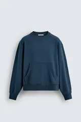 Sudadera azul petróleo de corte relajado, cuello redondo, manga larga, bolsillo tipo canguro y terminaciones en rib.