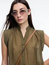 Camisa negra sin mangas con cuello mao y cierre frontal con botones.