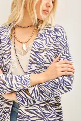 Saco tipo cardigan abierto con estampado animal print en tonos blanco, azul y dorado. Posee bordados de lentejuelas.