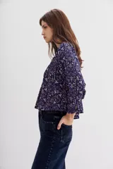 Blusa amplia de mangas largas y cuello redondo, estampada con detalles de lurex, punto smock en el frente y frunces en la espalda.