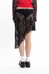 Pollera corta de encaje negro, con diseño asimétrico e irregular en el ruedo.