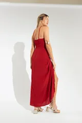Vestido largo lila con escote halter cruzado en la espalda y falda tipo pareo con abertura lateral y nudo decorativo.
