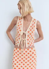 Falda corta de tejido crochet con diseño de flores en naranja y crema, bajo festoneado.
