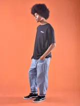 Remera negra de corte oversized con estampado pequeño en el pecho con la palabra "Mickey" en color verde.